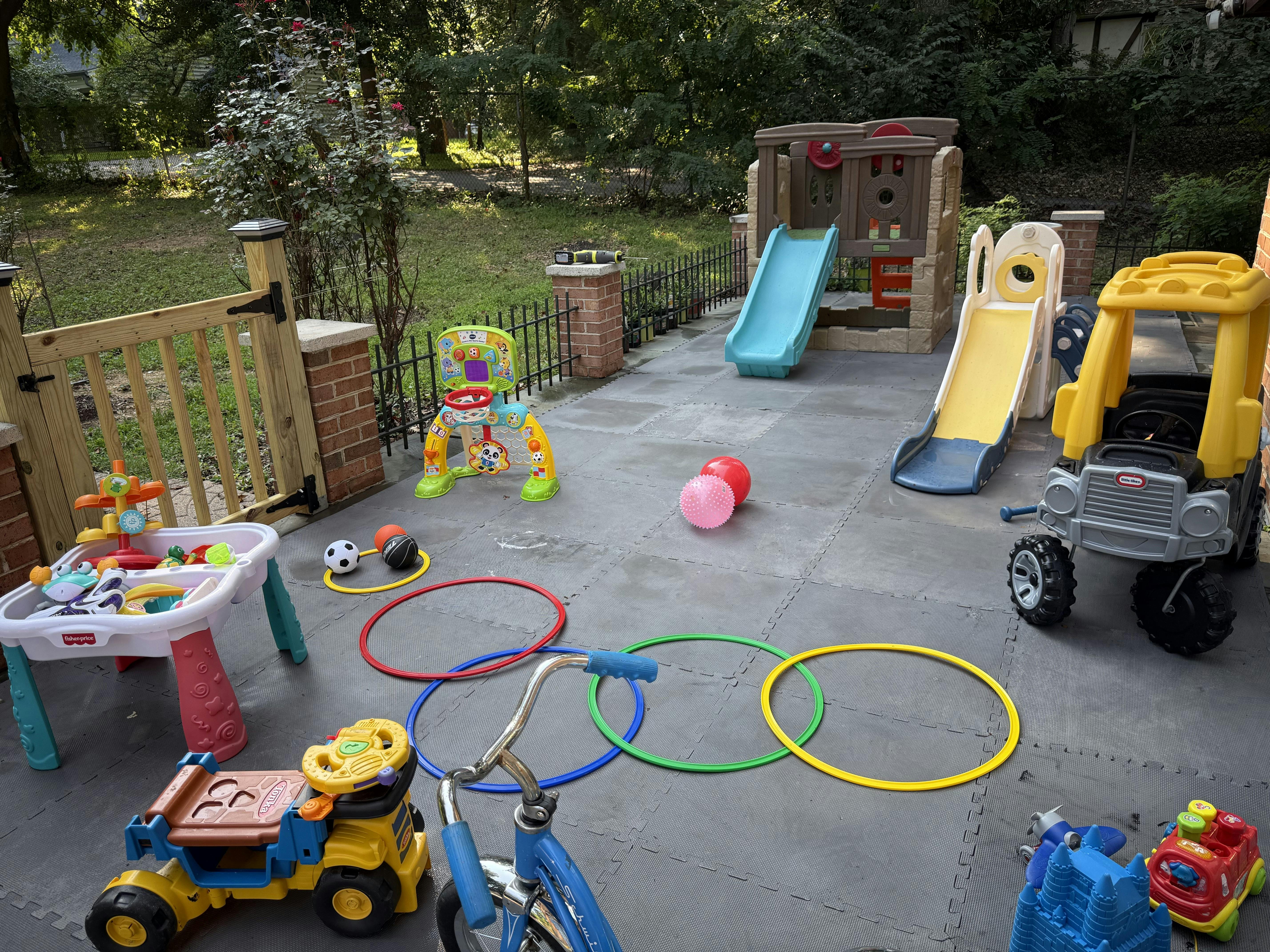 assortment of colorful children's outdoor toys on a patio