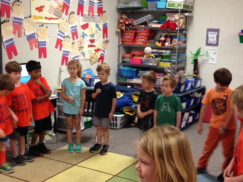 Group of children standing in a classroom