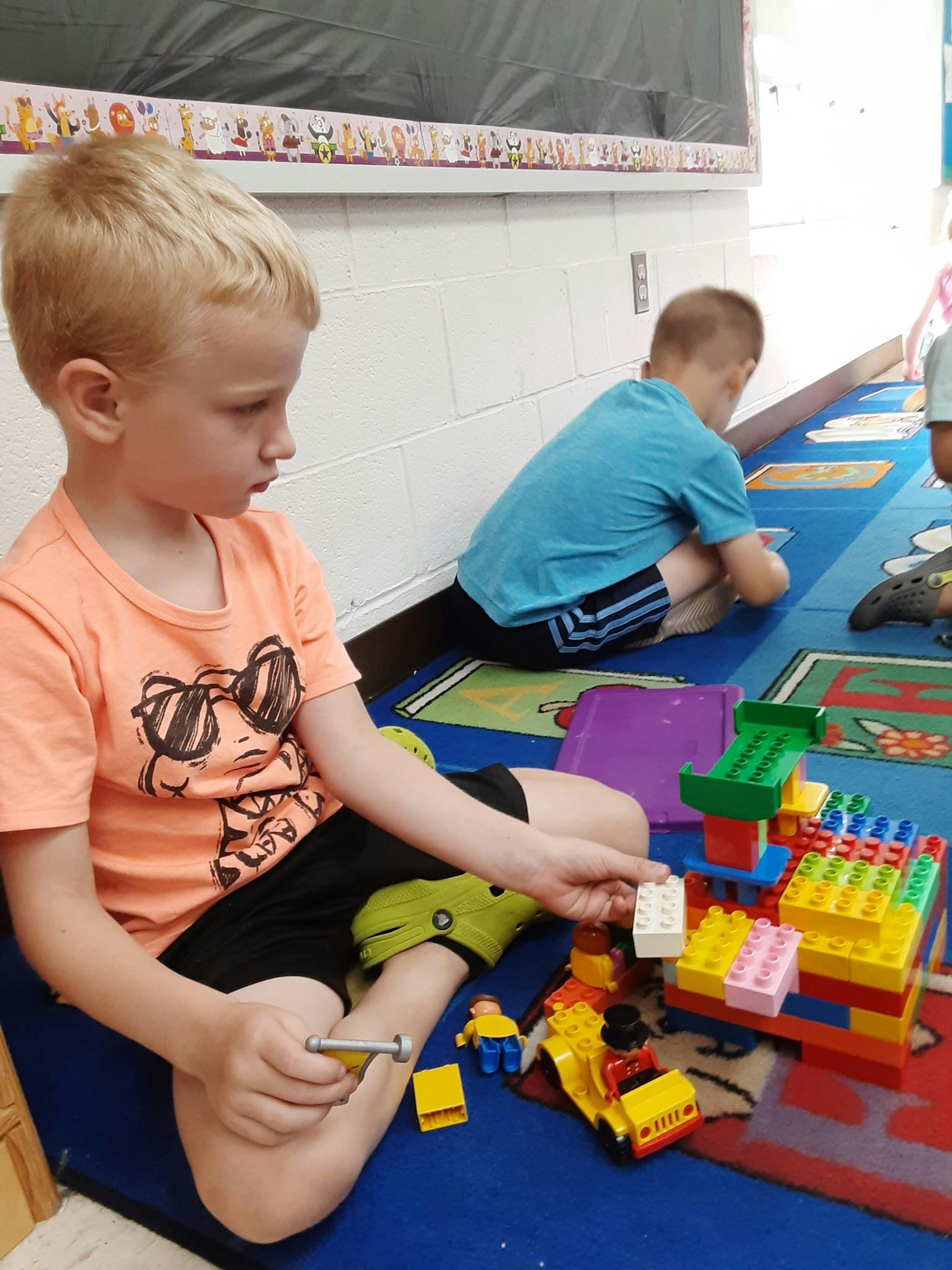 Child playing with building blocks on a rug