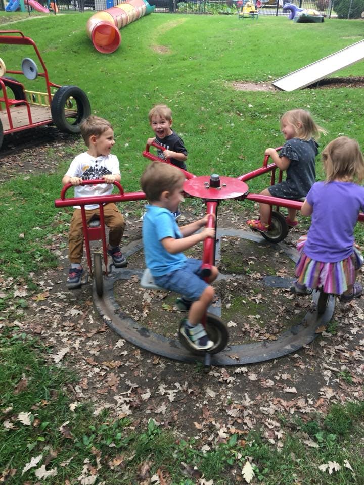 Children playing on a spinning playground ride