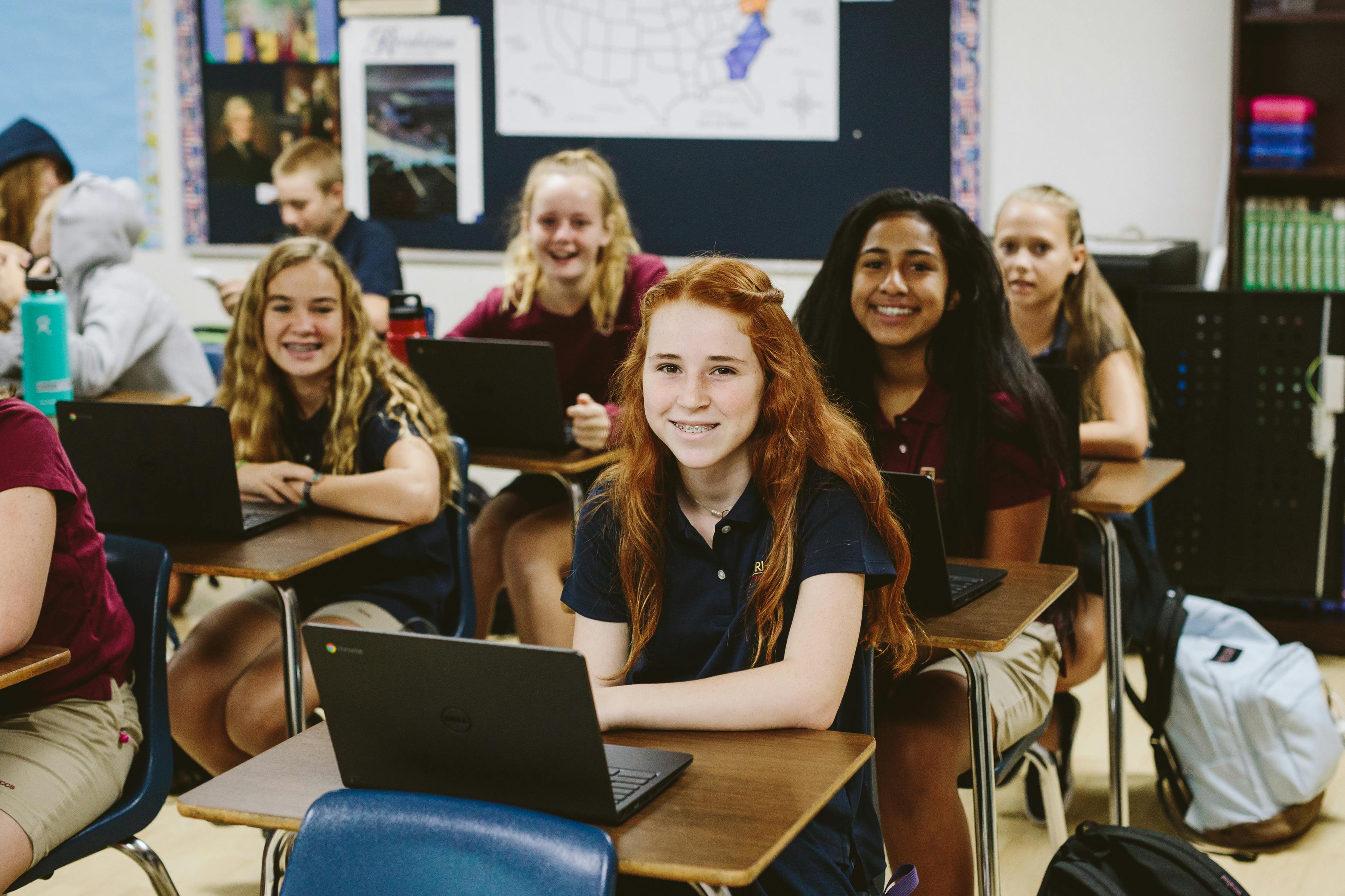 Teens and children in a classroom with laptops