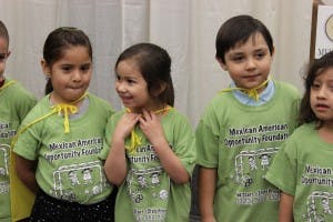 Children wearing green shirts and yellow capes
