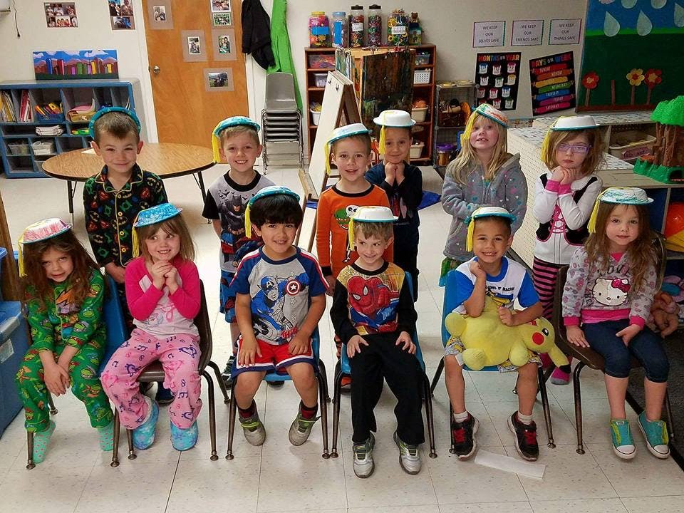Group of children wearing paper hats in a classroom