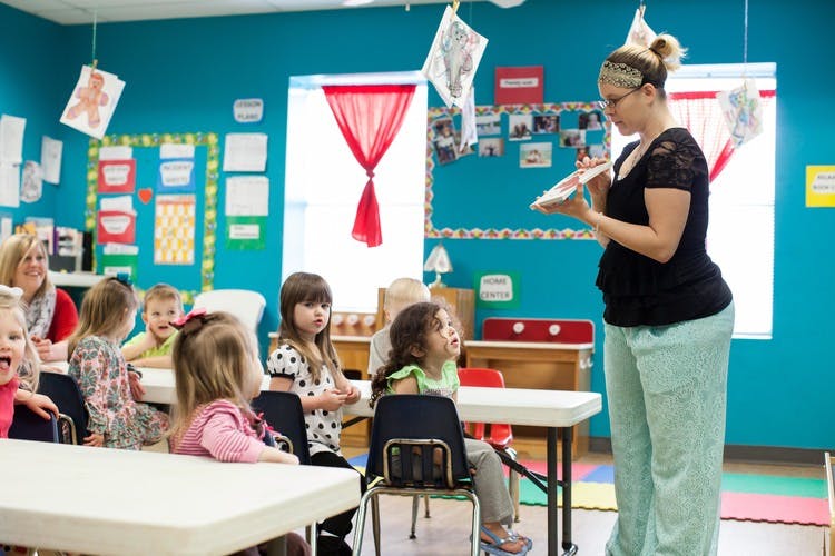 Adult reading to children in a classroom