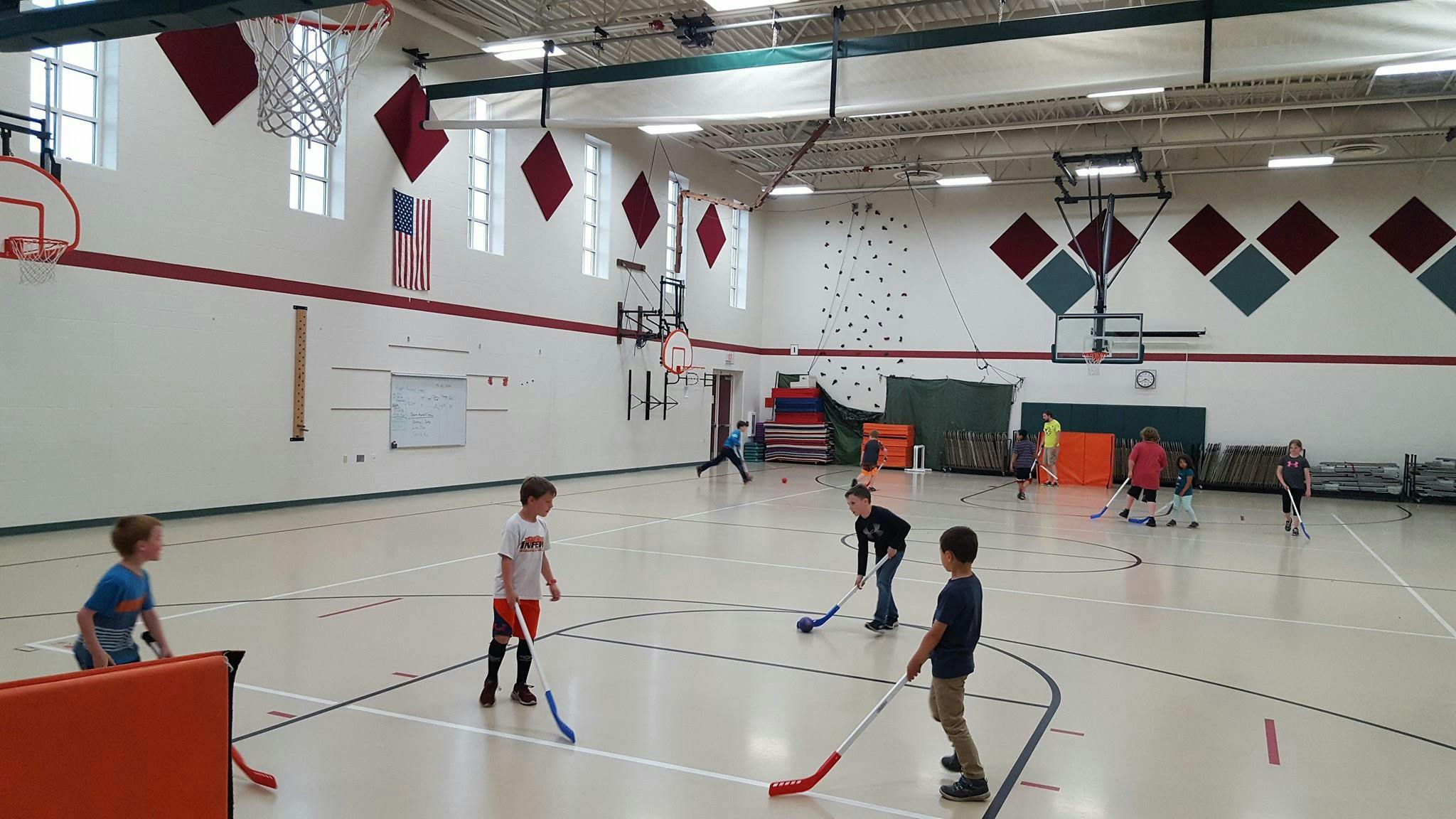 Children playing floor hockey in a gymnasium