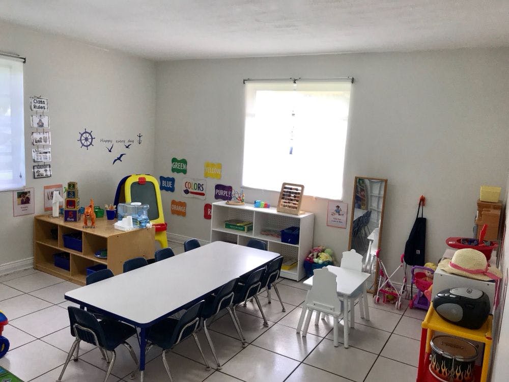 Classroom with a long table and chairs, shelves, and a window