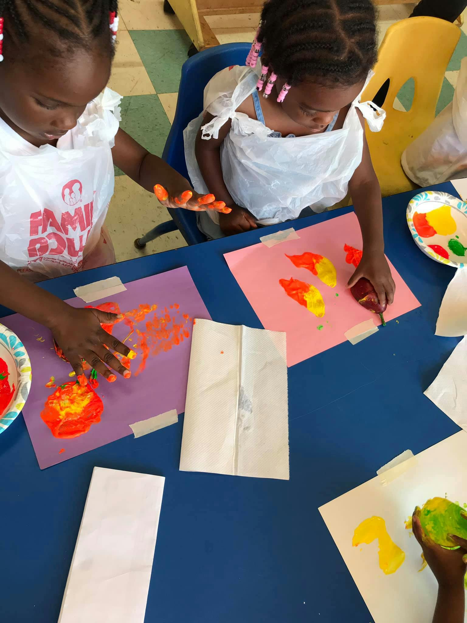 Two children finger painting at a table