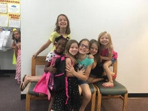 Seven children posing together on a bench