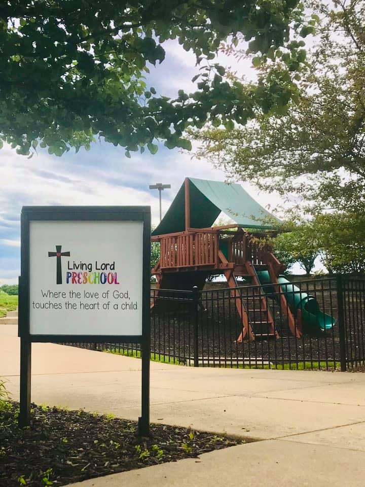 Sign for Living Lord Preschool next to a playground