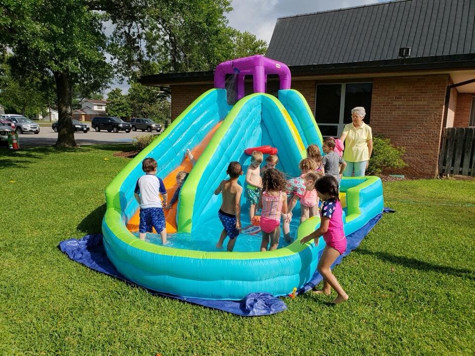 Children playing in an inflatable water slide and pool