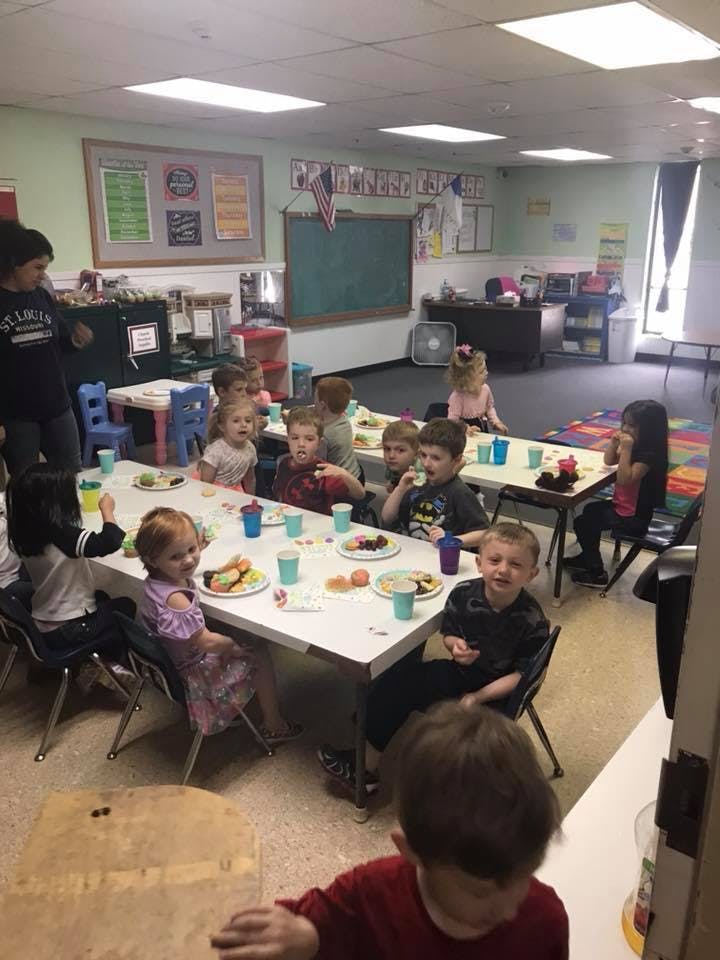 Children eating at tables in a classroom