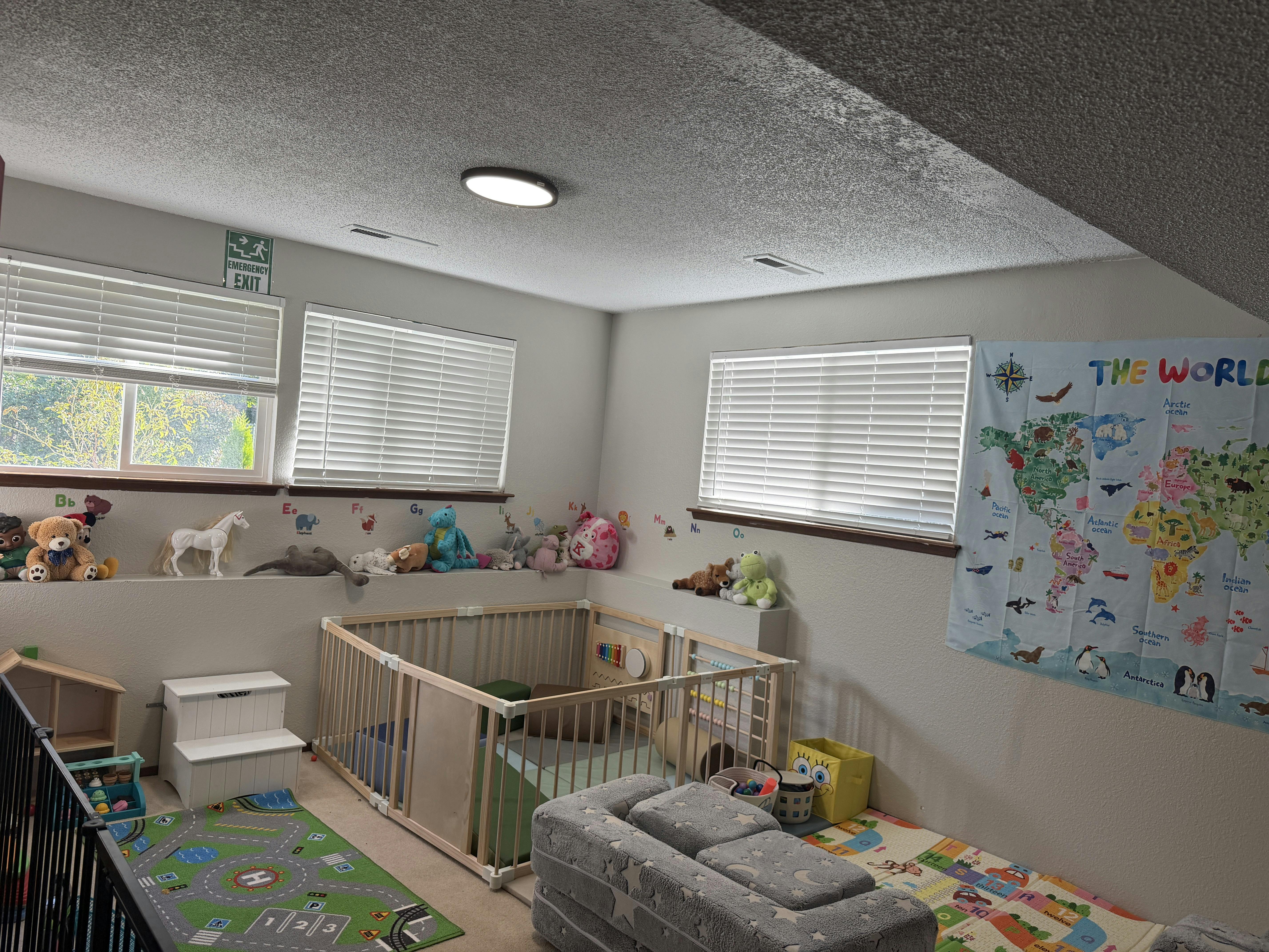 Playroom with toys, a playpen, and a wall map of the world
