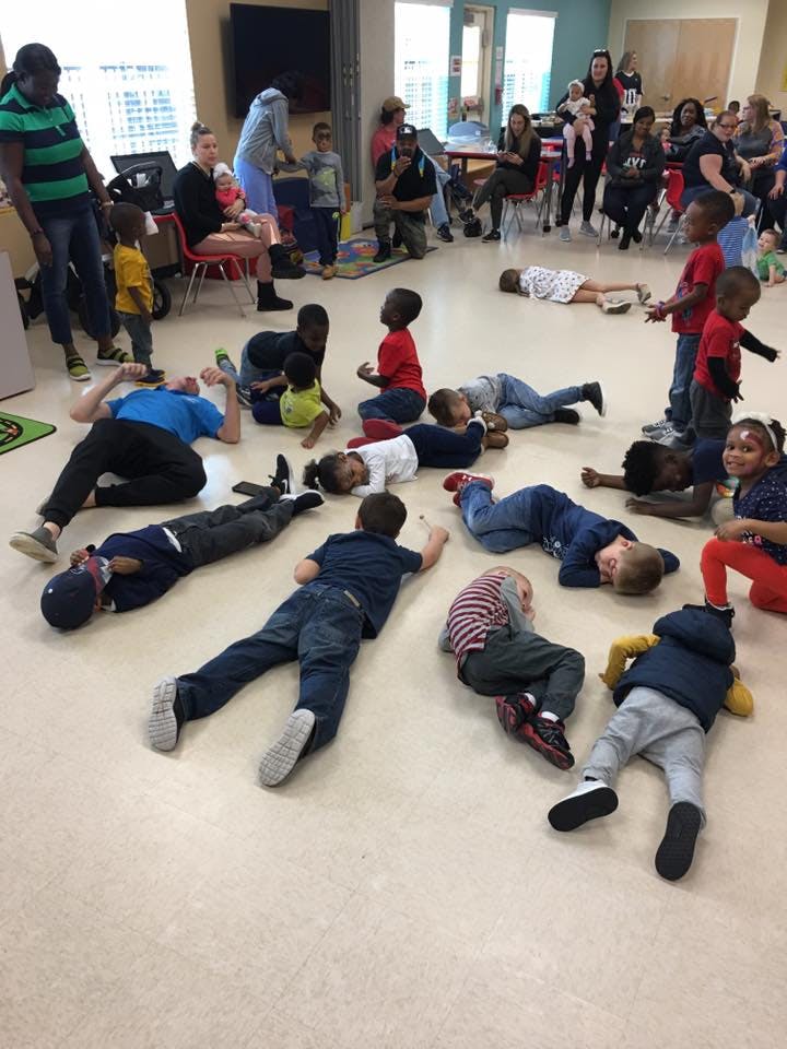 Children and adults lying on the floor in a room