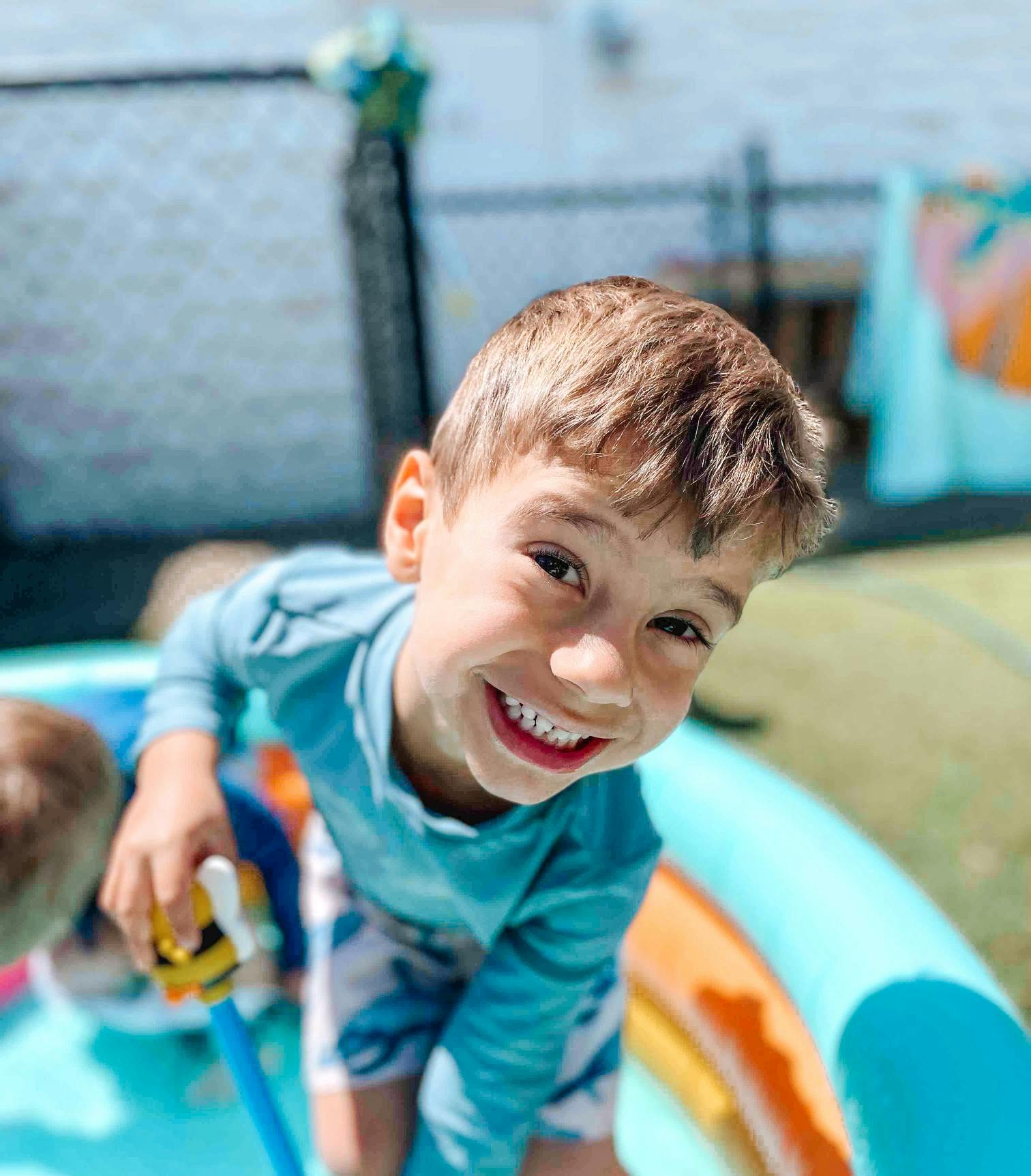 Child smiling in a wading pool