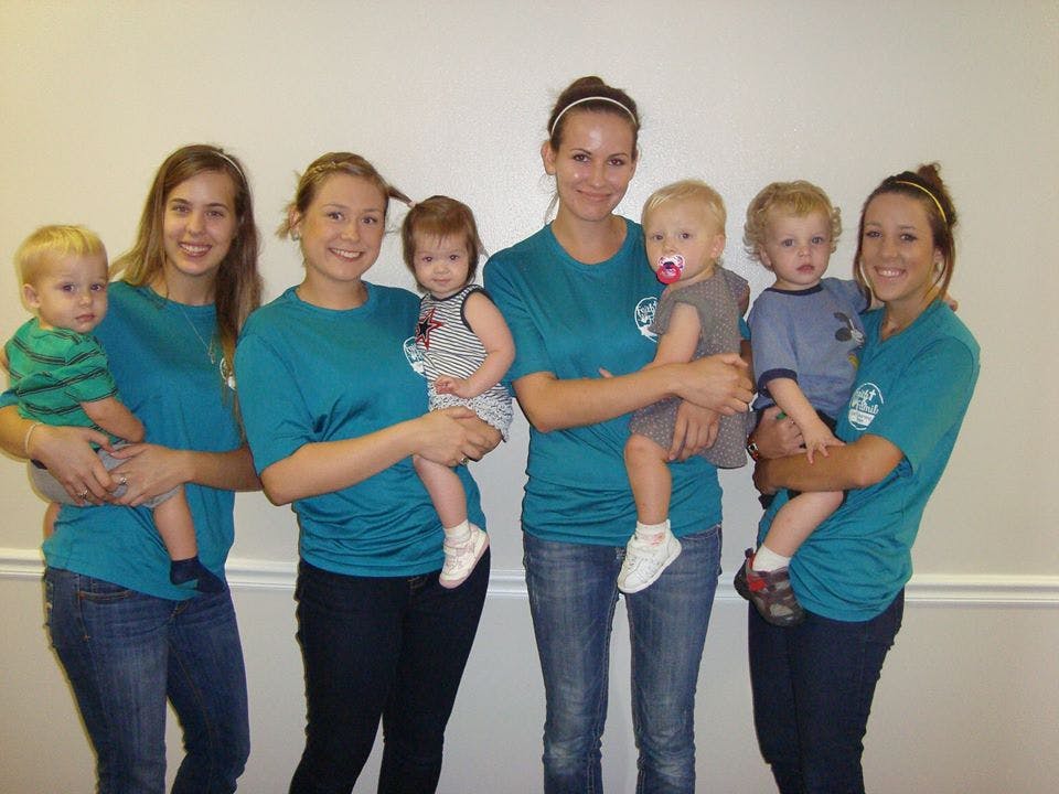 Four people holding four children