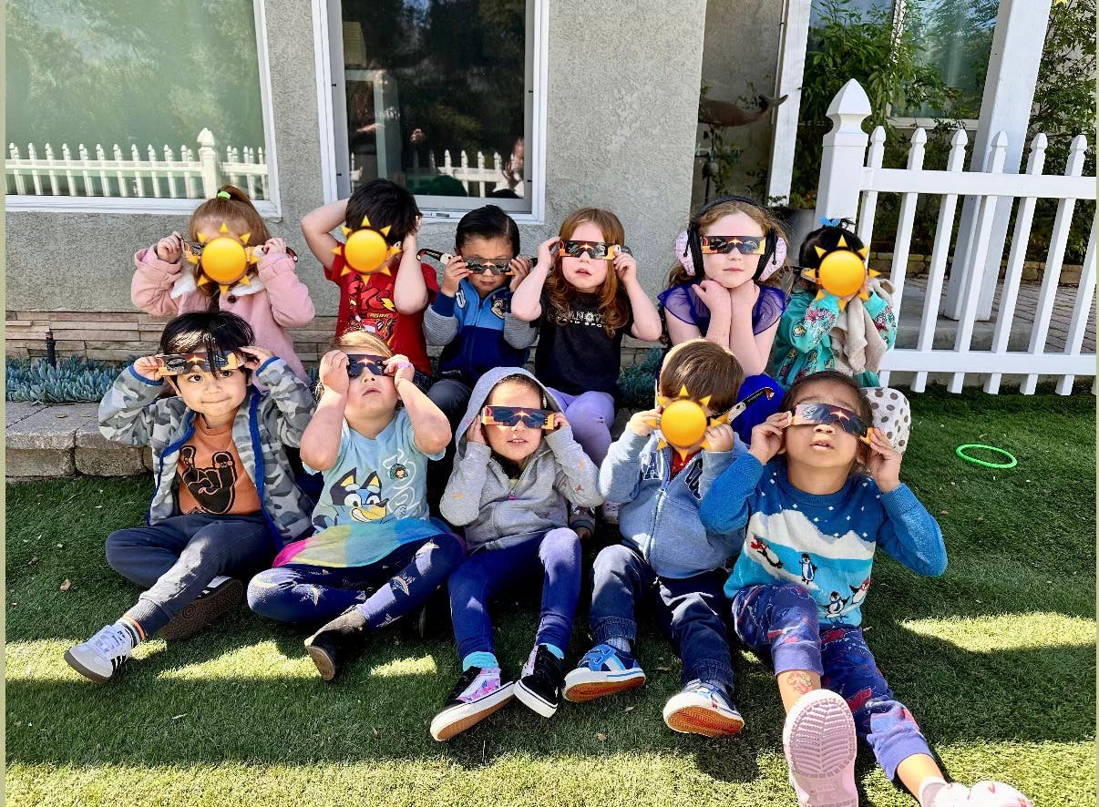 Group of children wearing eclipse glasses outdoors