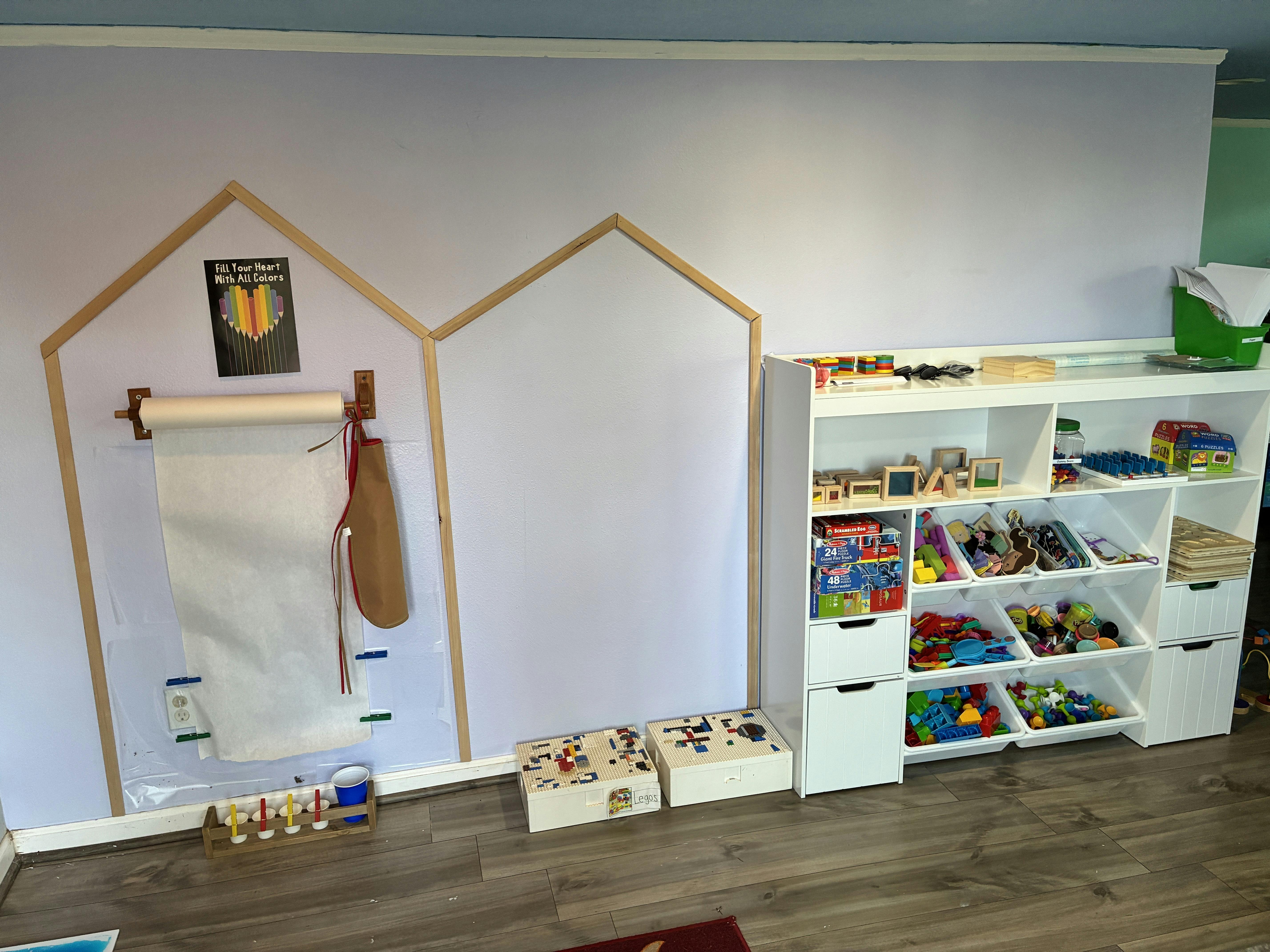 Children's art station with a paper roll, apron, and a toy organizer