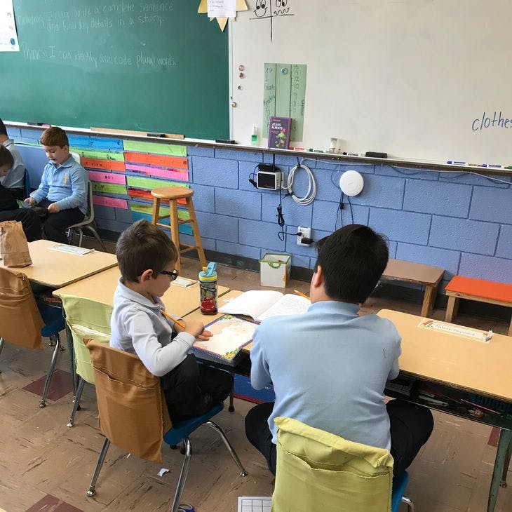 Two children sitting at desks in a classroom