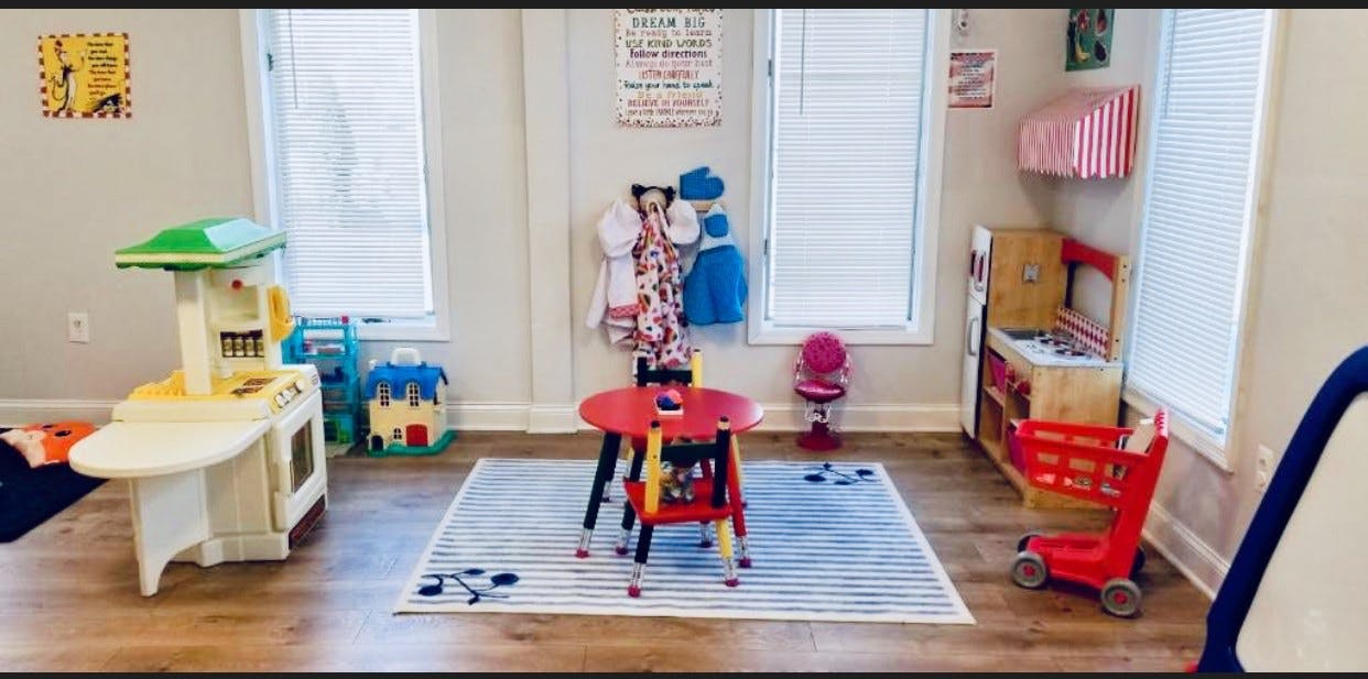 Playroom with toy kitchen, table, and shopping cart