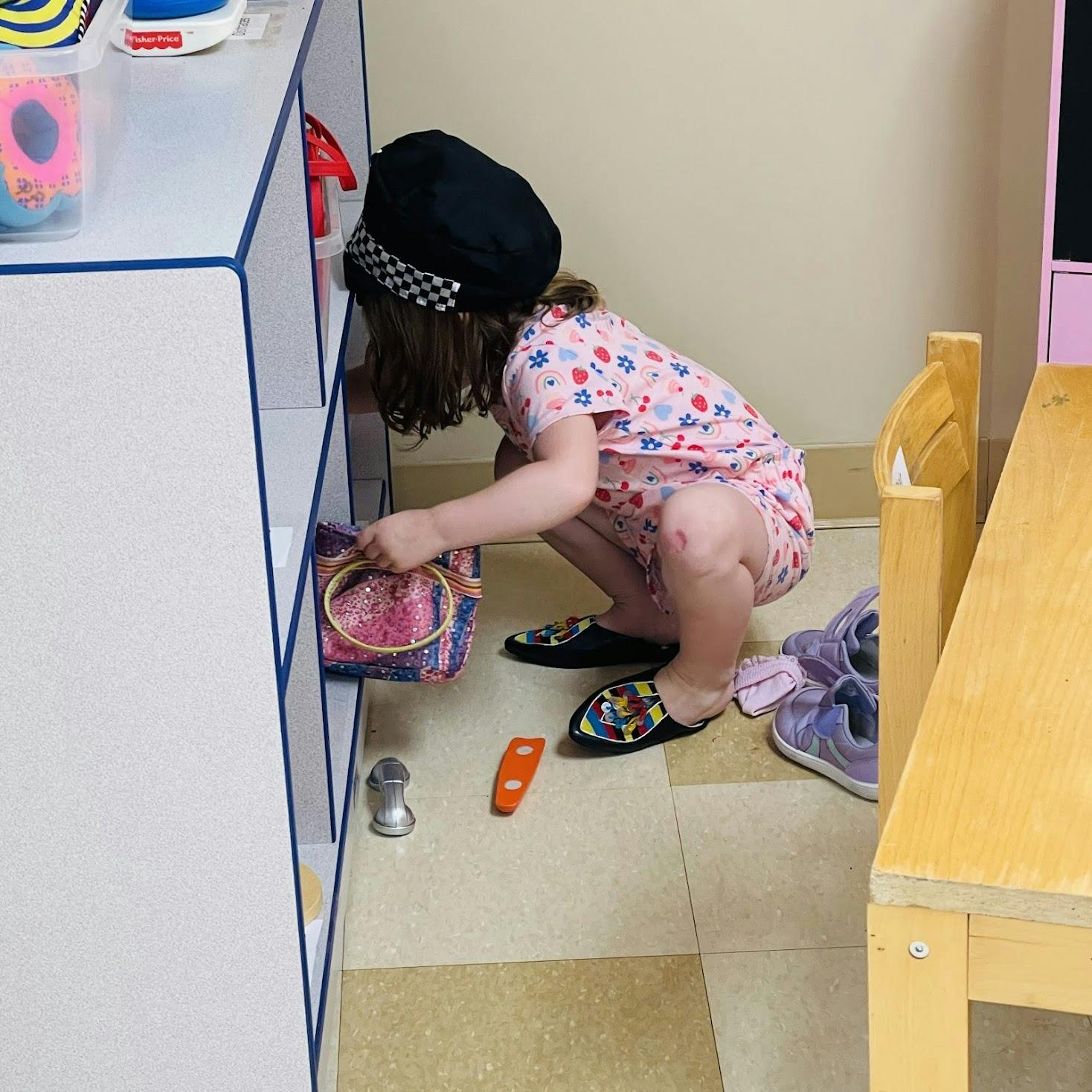 Child wearing a hat reaching for an item on a shelf