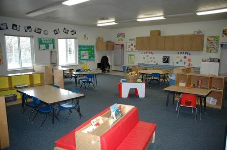 Classroom with tables, chairs, and storage units