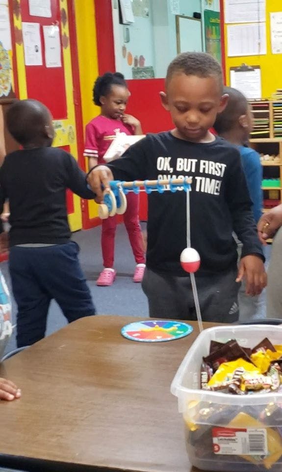 Child playing a fishing game in a classroom