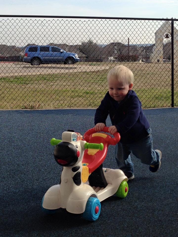 Child pushing a toy ride-on cow