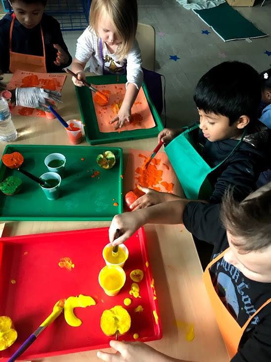 Children painting with fruit and vegetable stamps