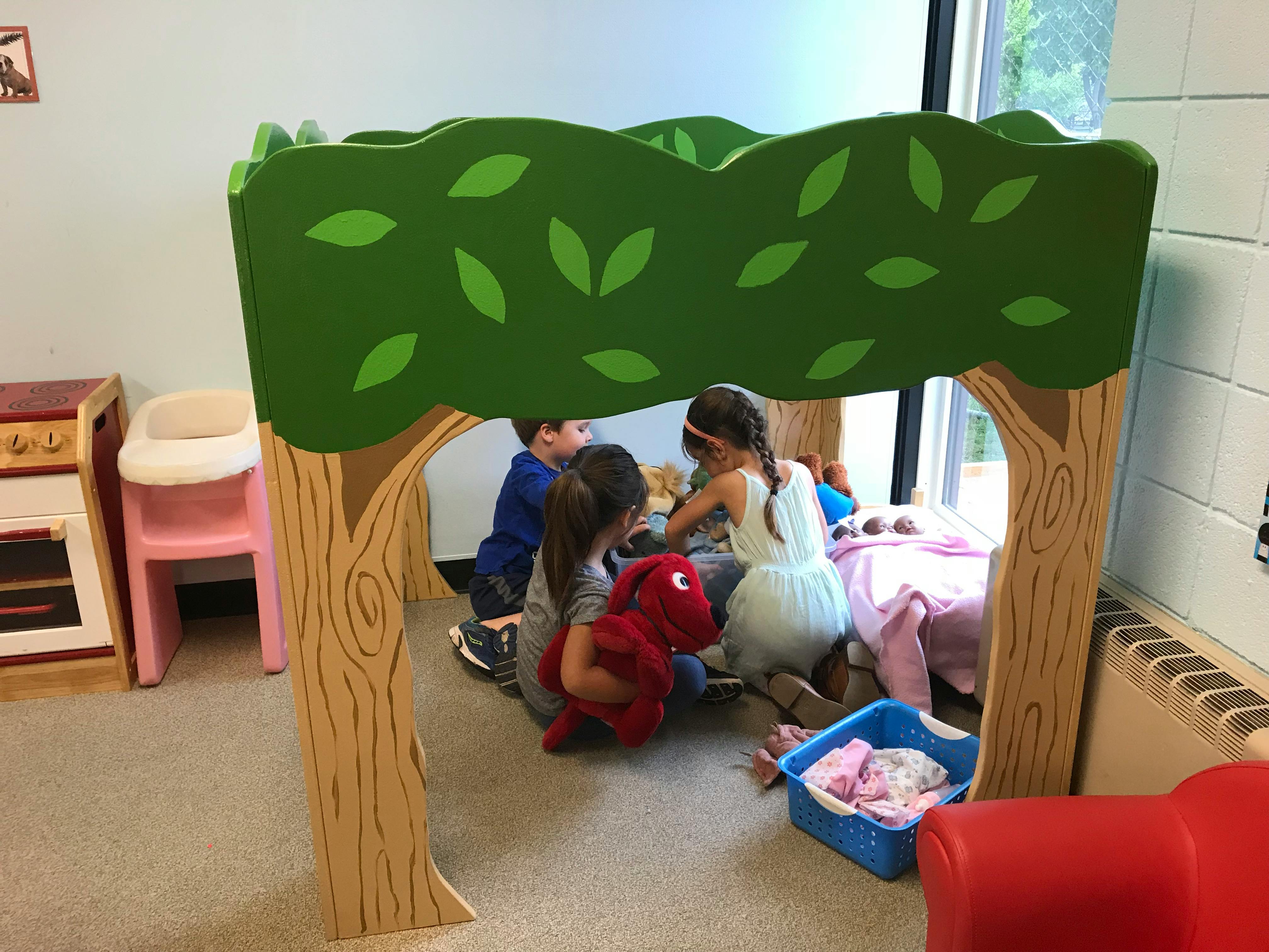 Children playing under a tree-shaped play structure