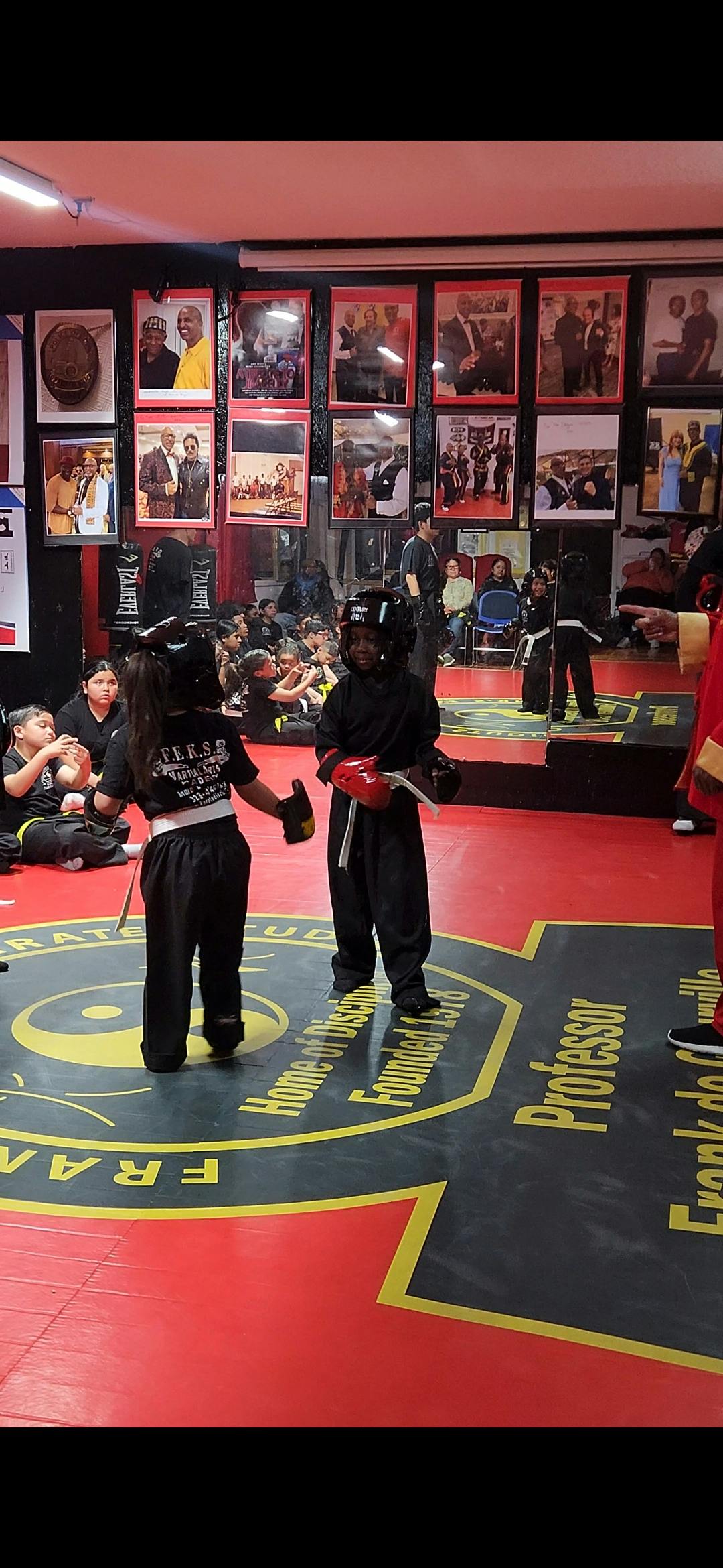 Children in martial arts gear with an audience