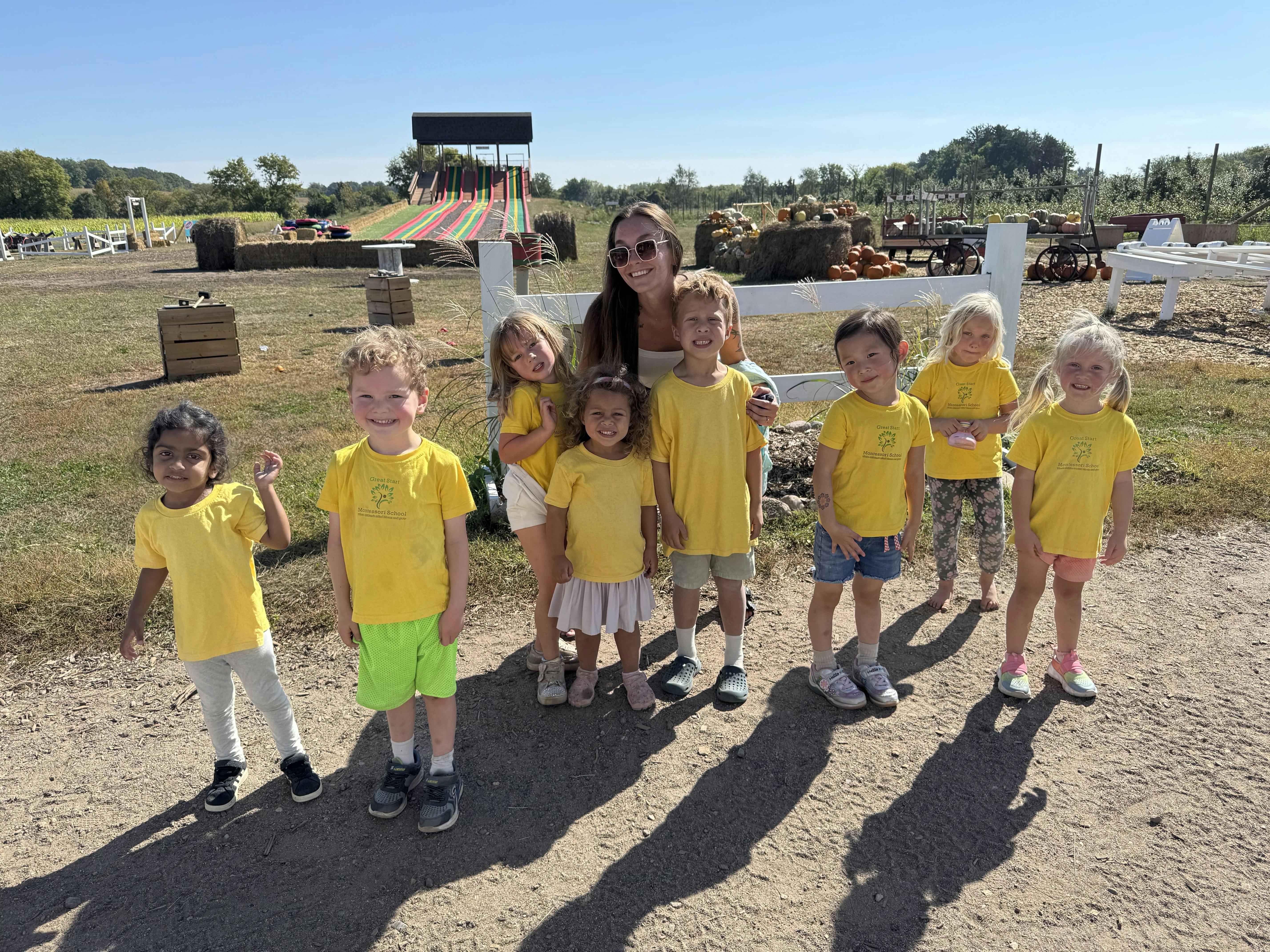 Adult and multiple children standing outdoors