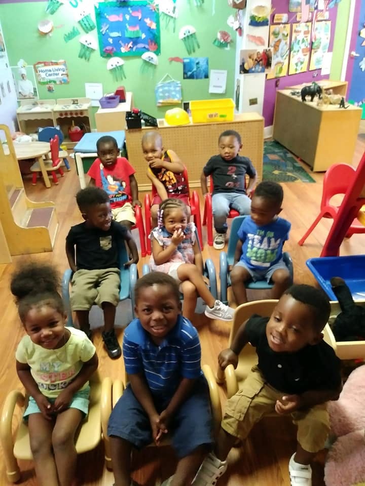 Group of children sitting in chairs in a classroom