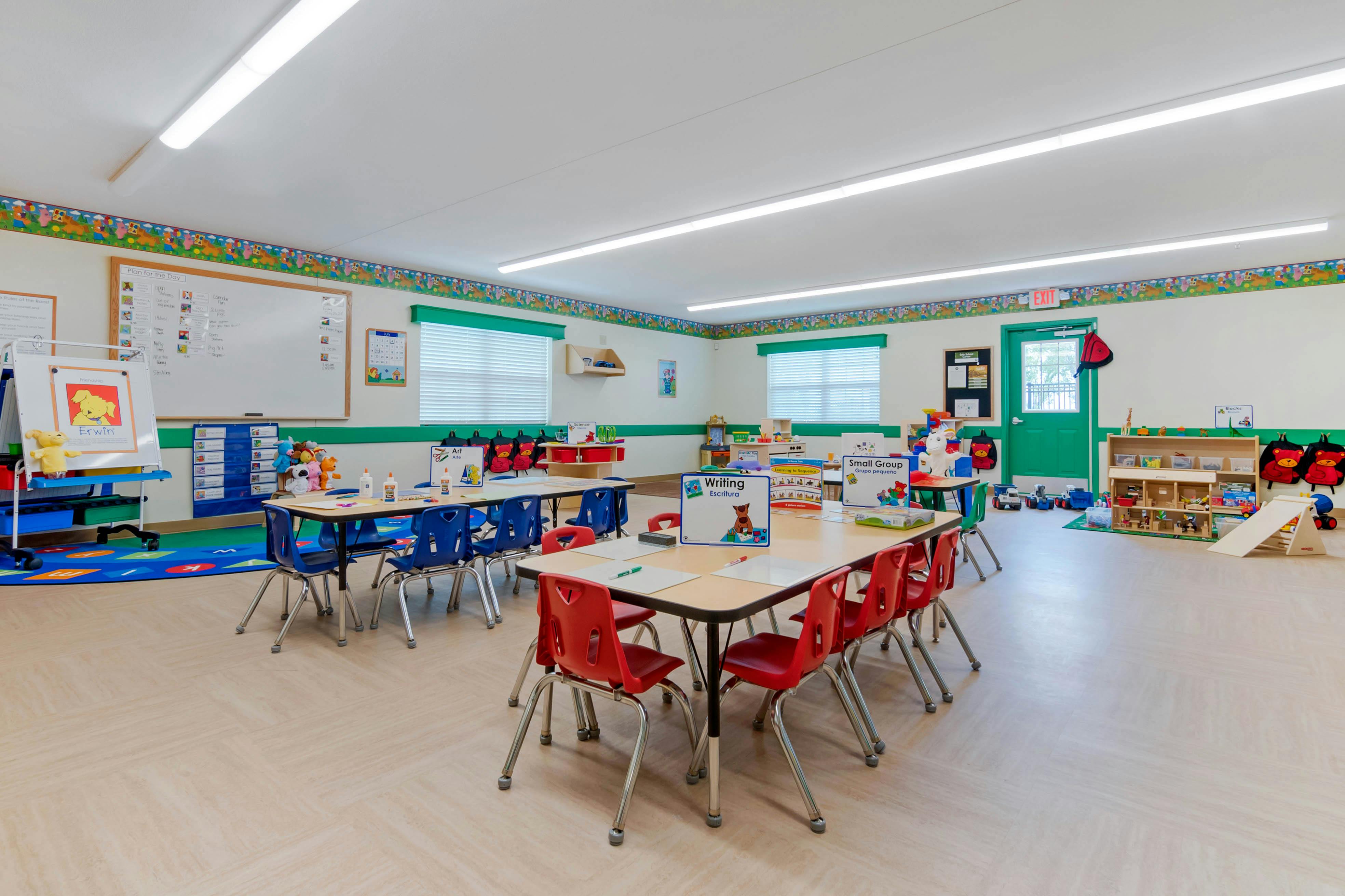 Classroom with small tables and chairs, whiteboards, and learning materials