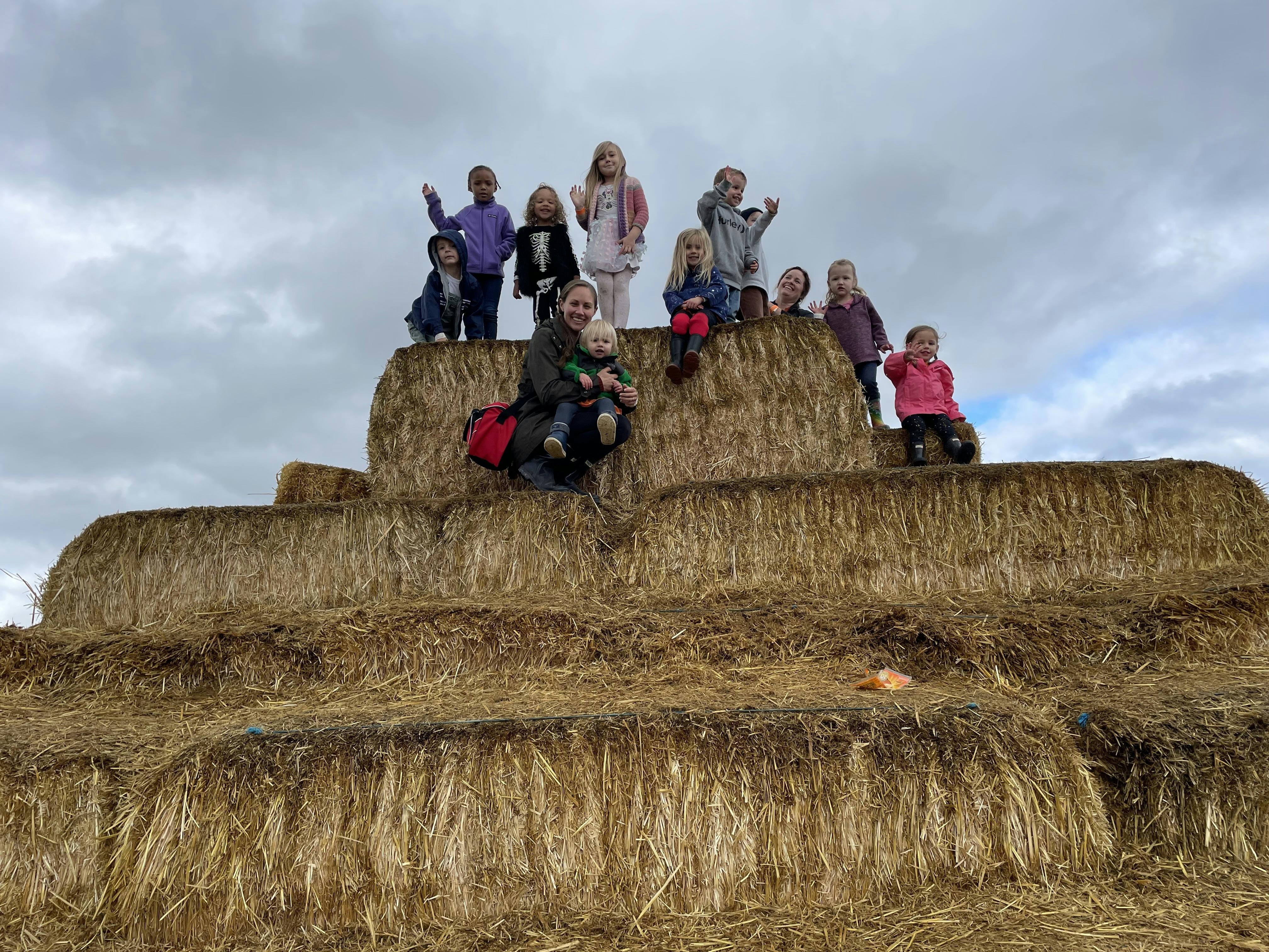 People and children on a hay bale pyramid