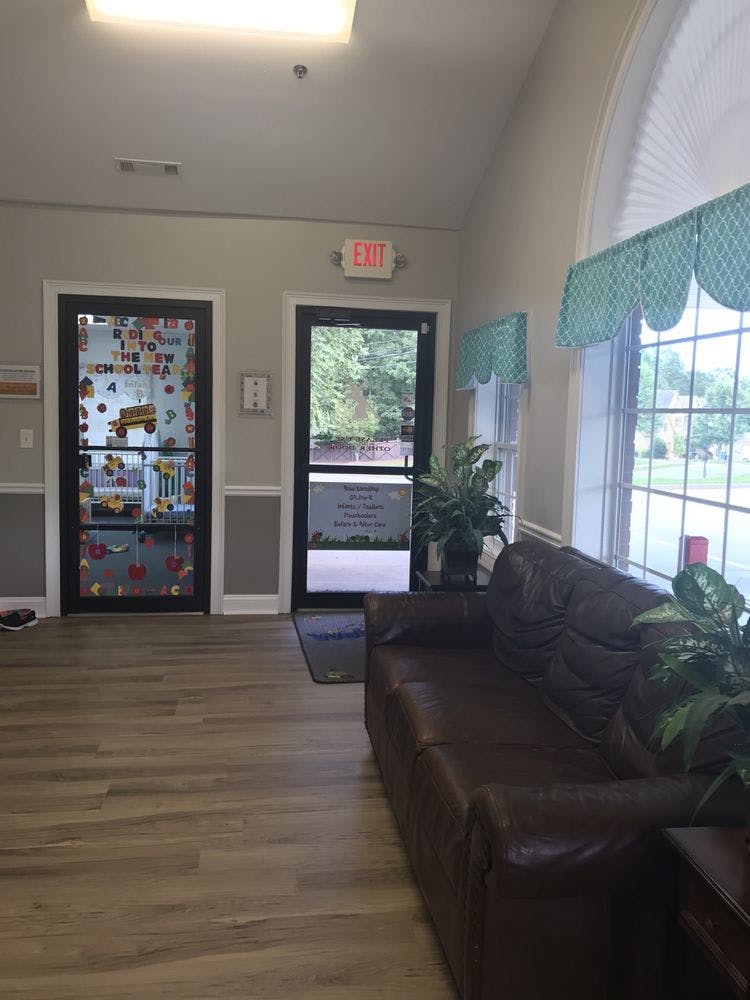 Lobby with a brown couch, two doors, and a large window