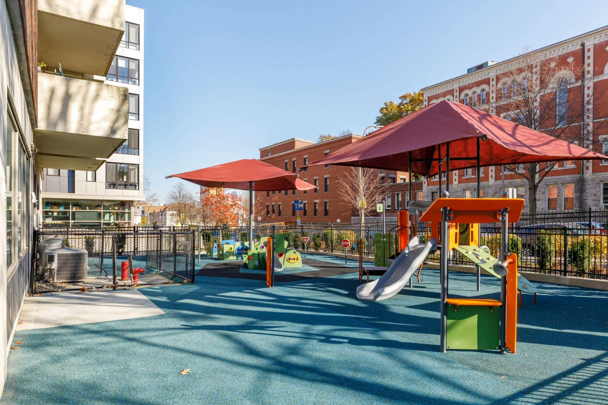 Empty children playground with colorful equipment and shade structures