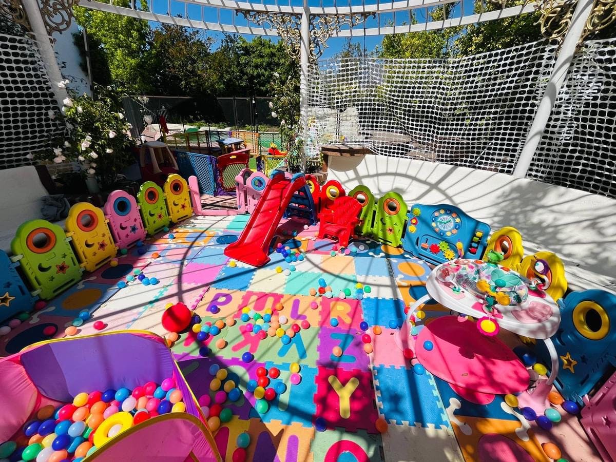 Children's play area with colorful mats, ball pit, and slide