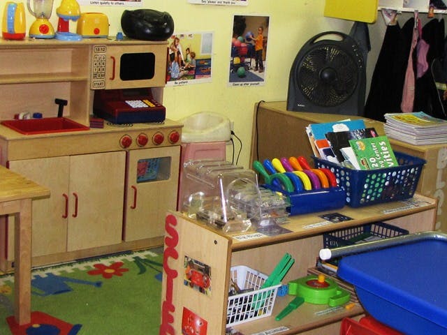 Play kitchen and shelves with toys in a classroom
