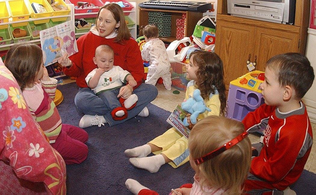 Person reading a book to children in a classroom