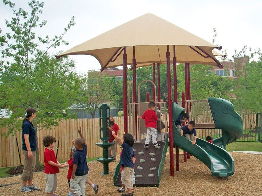 Children playing on a playground with slides and climbing structures