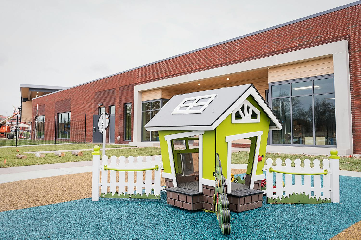 Playhouse with white picket fence on a playground