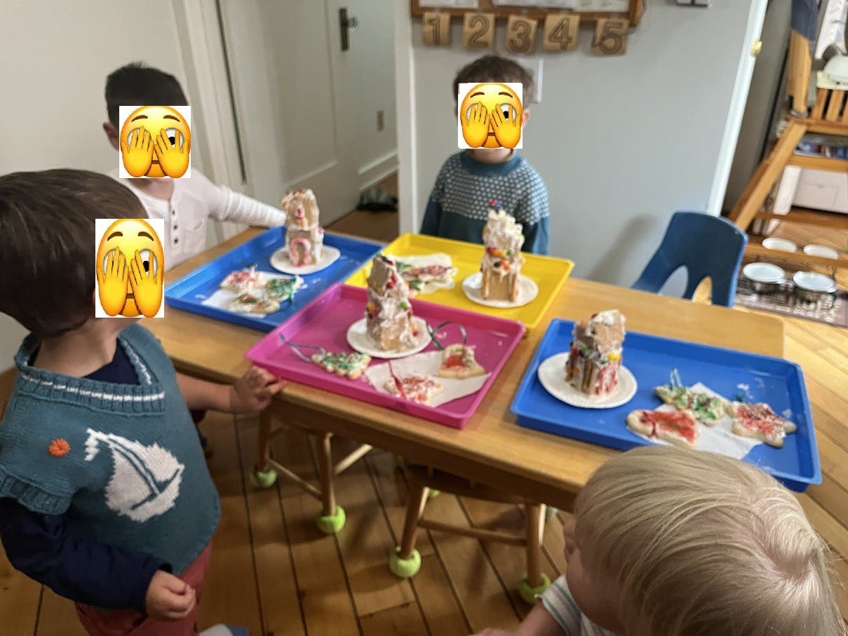 Children decorating gingerbread houses at a table