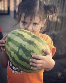 Child holding a watermelon