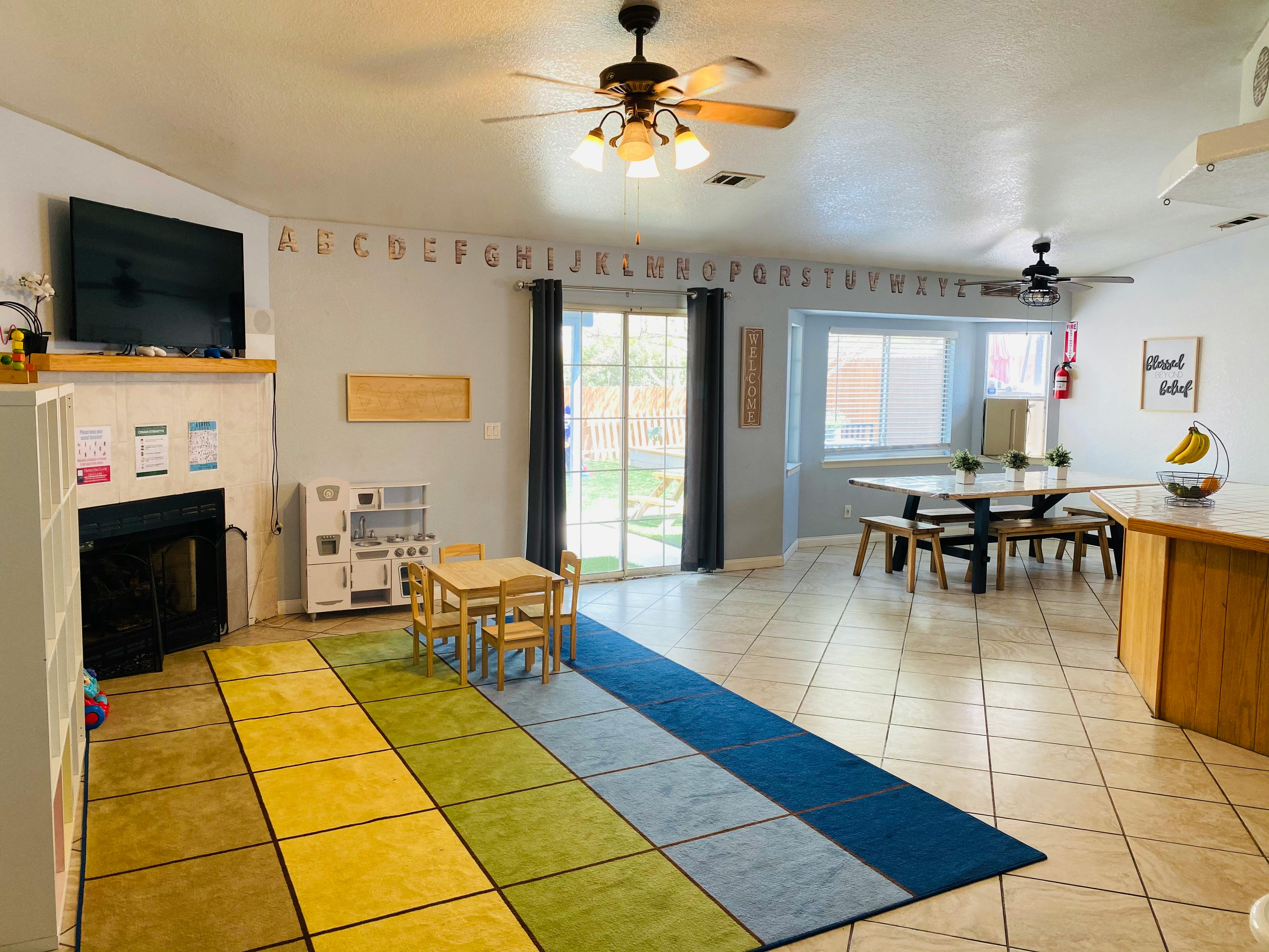 Room with a small table and chairs, a large dining table, and a television