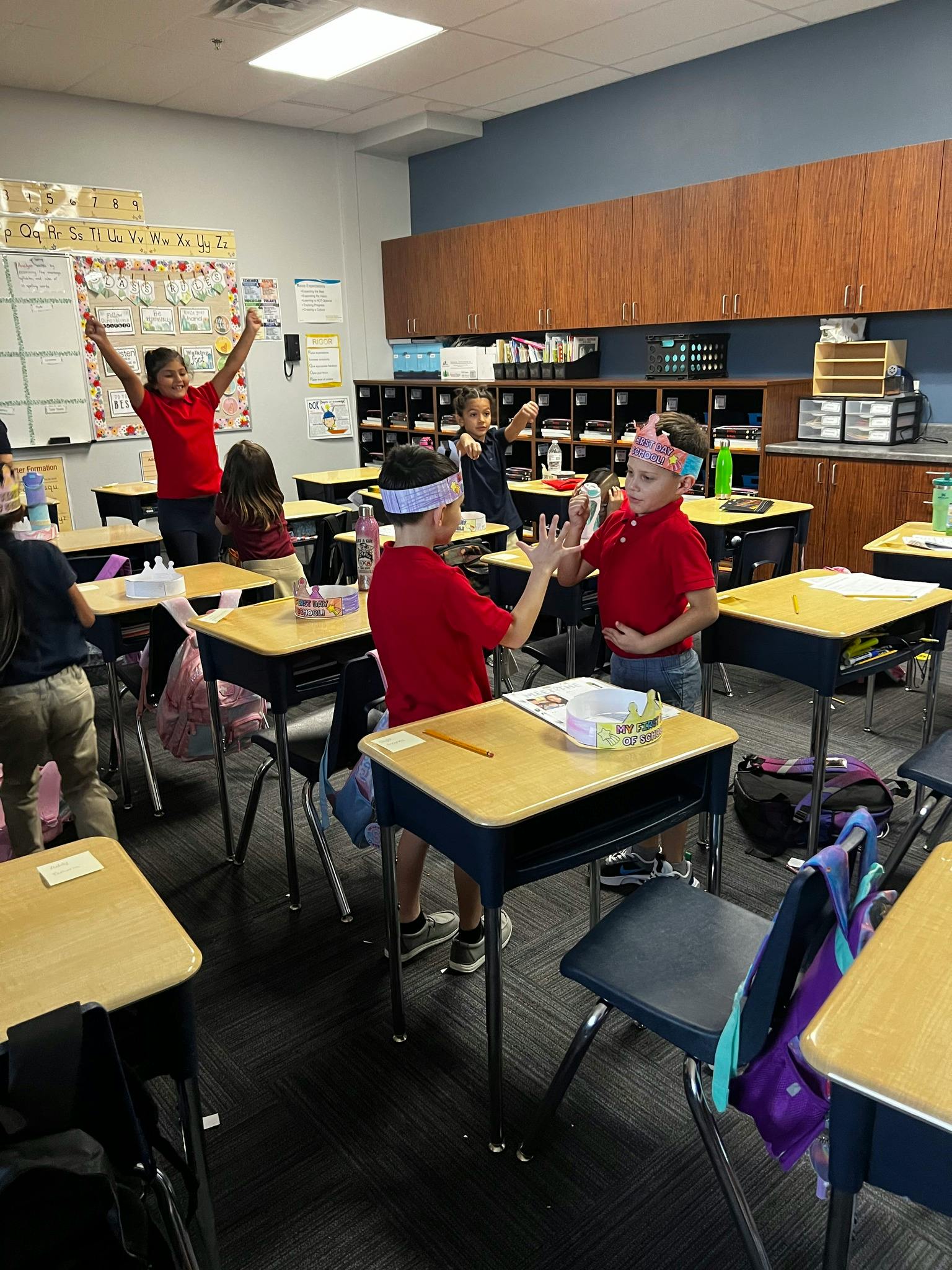 Children in a classroom, some standing and interacting