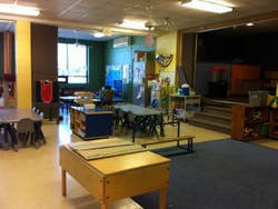 Classroom with tables and chairs, a stage to the right