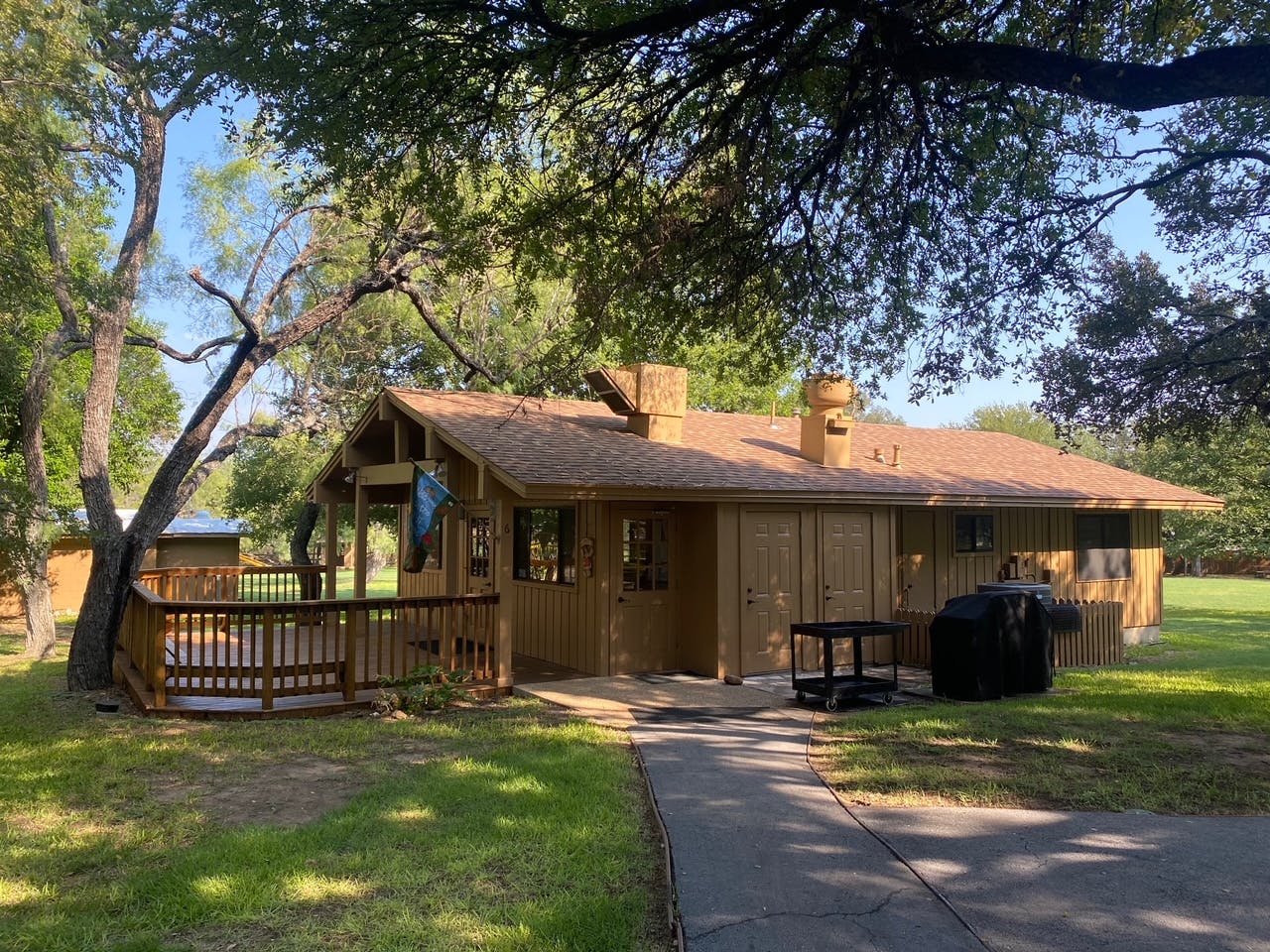 Wooden cabin with a porch and a paved path leading to the entrance