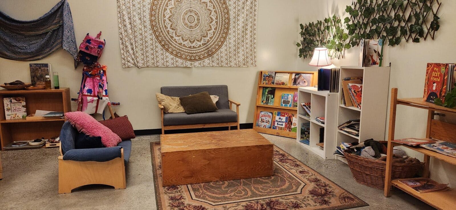 Room with children's furniture, shelves with books and toys, and a rug