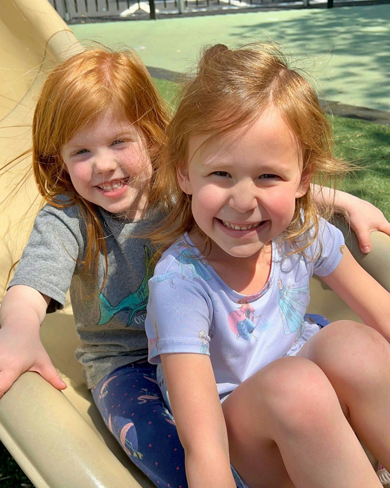 Two children sitting on a slide