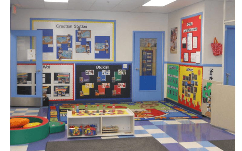 Children's classroom with educational posters, colorful rug, and toy storage